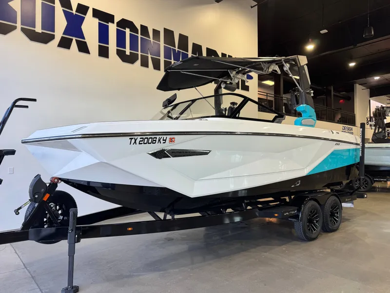 Slide: The Image of A 2024 Super Air Nautique G23 boat on a trailer in a showroom. - 2