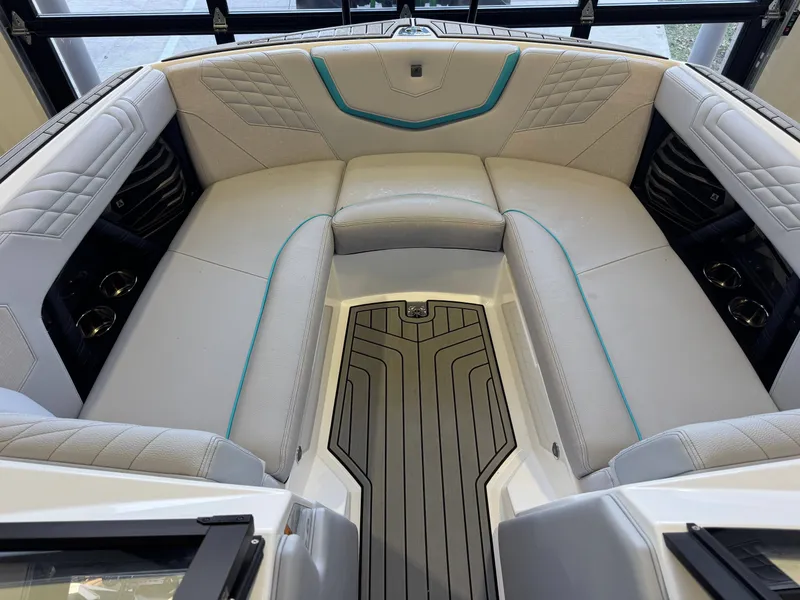 Slide: The Image of The image shows the bow area of a 2024 Nautique Super Air Nautique G23 with cushioned seating. - 18