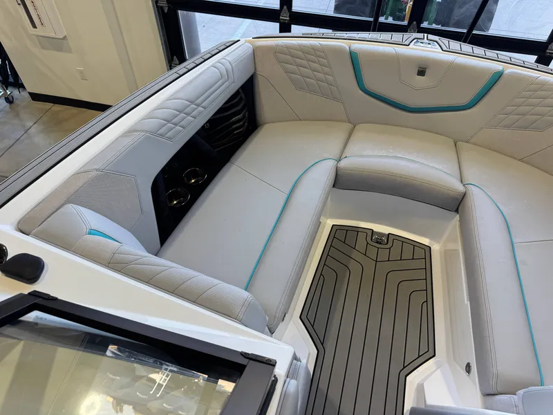 Slide: The Image of The image shows the interior of a 2024 Super Air Nautique G23 with gray upholstery and turquoise accents. - 20