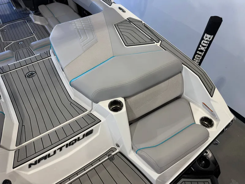 Slide: The Image of The image shows the stern of a 2024 Super Air Nautique G23 with gray upholstery and blue accents. - 12