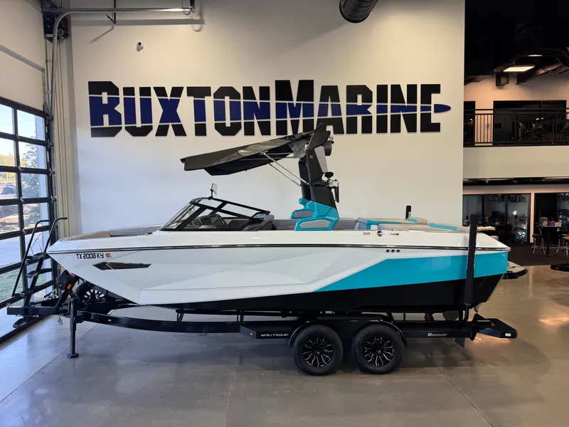 The Image of A 2024 Super Air Nautique G23 boat on a trailer in a showroom. - 1