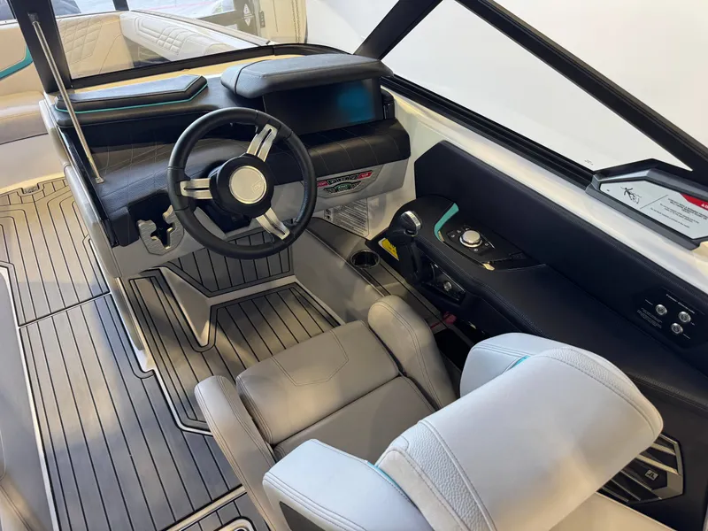 Slide: The Image of The cockpit of a 2024 Super Air Nautique G23 with a modern steering wheel and gray upholstery. - 26