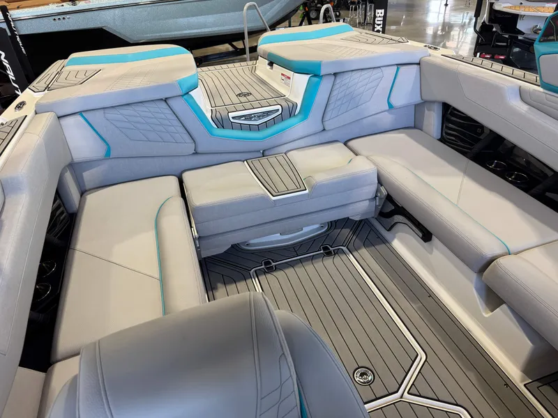 Slide: The Image of The image shows the luxurious interior of a 2024 Super Air Nautique G23 with gray and blue upholstery. - 17