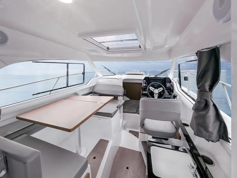 Slide: The Image of Manufacturer Provided Image: 2025 Beneteau Antares 8 interior, featuring modern seating, steering wheel, and dining area. - 4