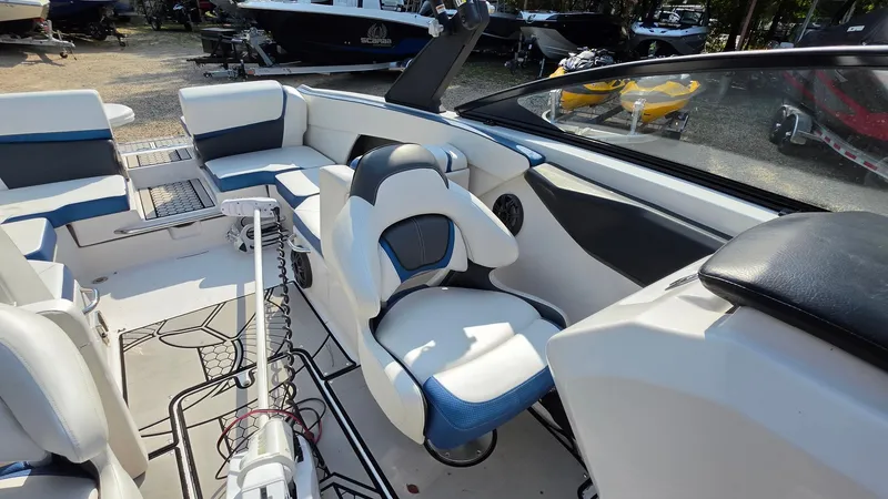 Slide: The Image of The image shows the cockpit of a 2019 Scarab 255 ID Wake Edition boat with white and blue seating. - 20