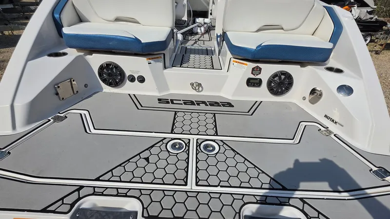 Slide: The Image of The image shows the rear of a 2019 Scarab 255 ID Wake Edition boat with cushioned seats and speakers. - 22