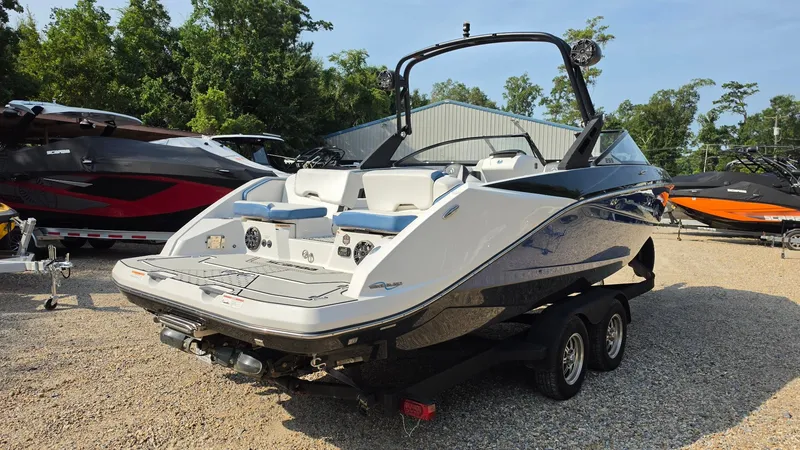 Slide: The Image of A 2019 Scarab 255 ID Wake Edition boat on a trailer. It features a sleek design with a black and white hull and a sturdy tower. - 4