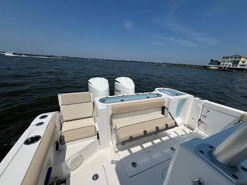 Slide: The Image of The image shows the stern of a 2018 Sea Fox 328 Commander with beige seating and two engines. - 21