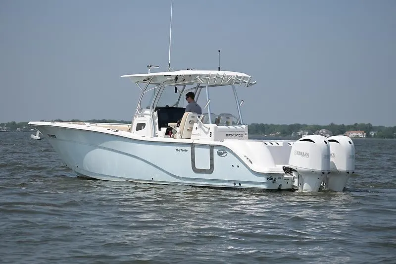 Slide: The Image of A 2018 Sea Fox 328 Commander on the water with twin outboard engines and a covered helm. - 25