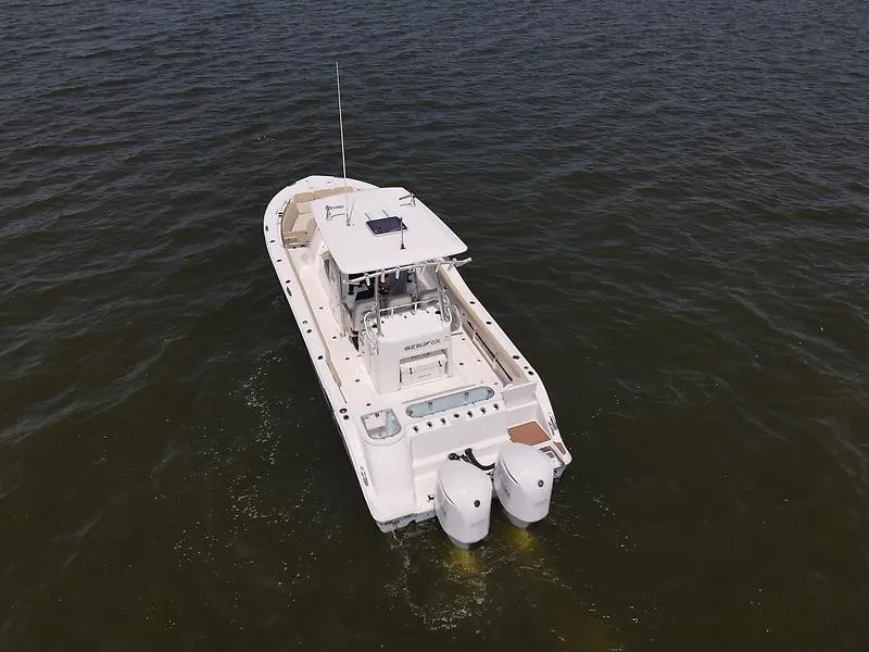Slide: The Image of A 2018 Sea Fox 328 Commander on the water with twin outboard engines and a spacious deck. - 9