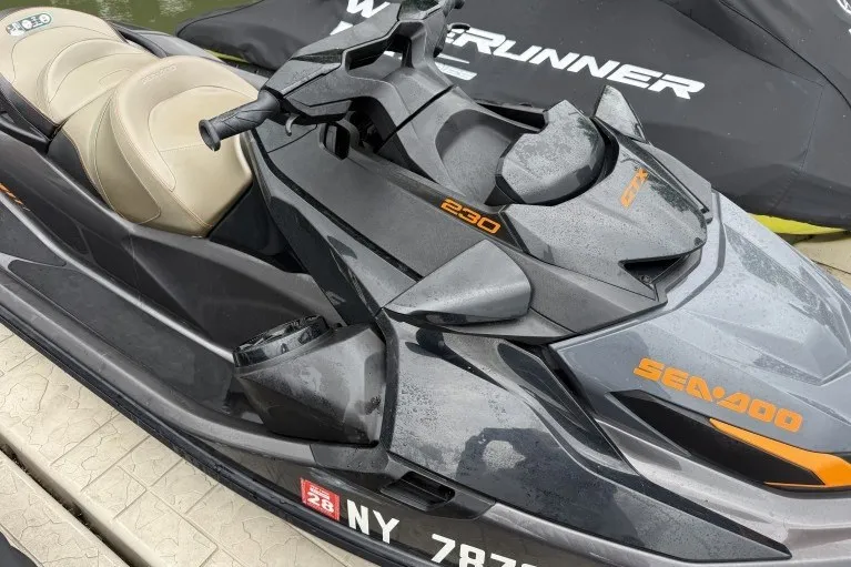 The Image of 2021 Sea-Doo GTX 230 jet ski with sleek design and beige seating on a dock. - 1