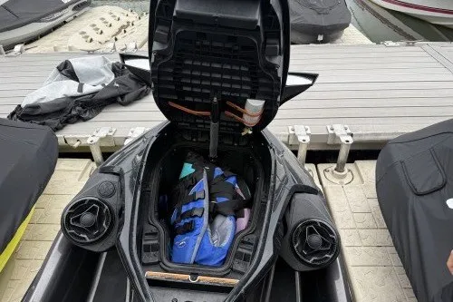 Slide: The Image of 2021 Sea-Doo GTX with open storage compartment, docked, showing life jacket inside. - 8