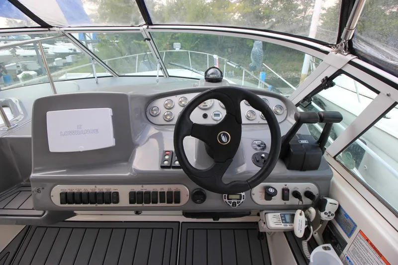 Slide: The Image of Helm of 2006 Cruisers Yachts 320 Express with steering wheel and navigation controls. - 12