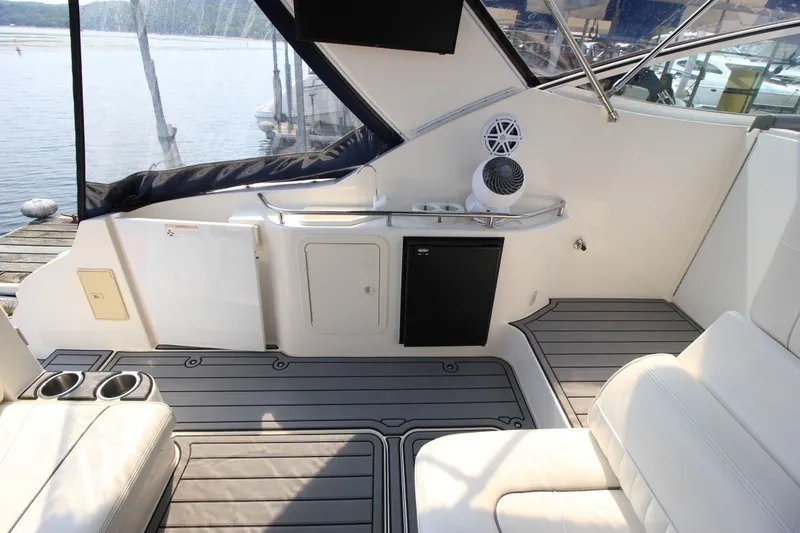 Slide: The Image of 2006 Cruisers Yachts 320 Express interior with seating, mini fridge, and lake view. - 5