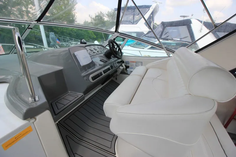 Slide: The Image of 2006 Cruisers Yachts 320 Express helm with white seating and modern dashboard. - 10