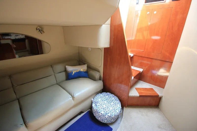 Slide: The Image of Interior of 2006 Cruisers Yachts 320 Express, featuring cozy seating and elegant wooden stairs. - 19