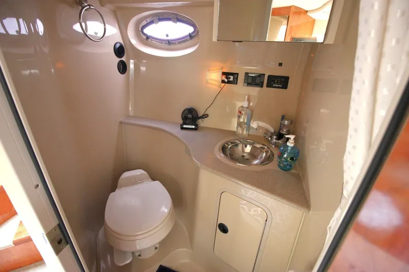 Slide: The Image of 2006 Cruisers Yachts 320 Express bathroom with sink, toilet, and porthole window. - 20