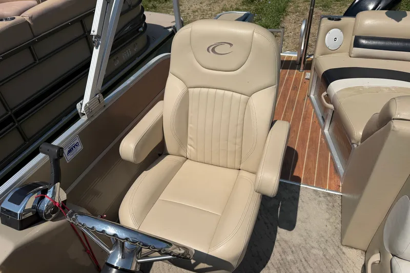 Slide: The Image of Captain's chair on 2012 Crest 230SLR Classic boat, featuring beige upholstery and steering wheel. - 9