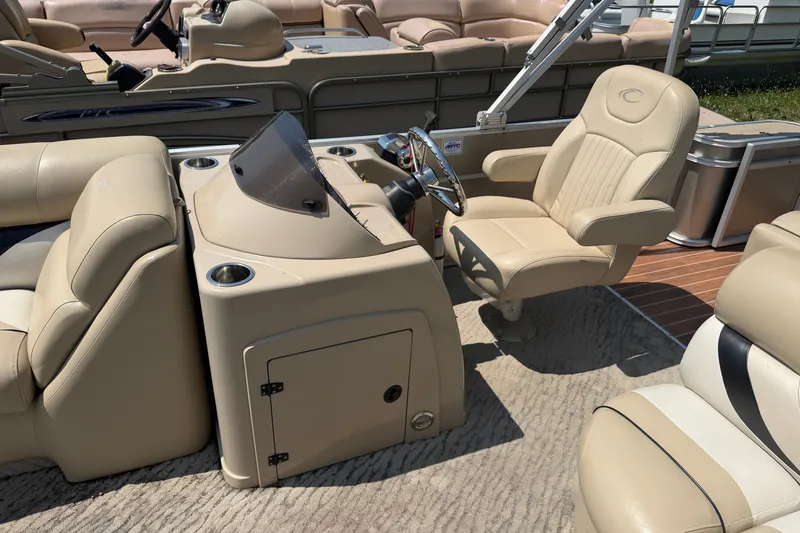 Slide: The Image of Interior of a 2012 Crest 230SLR Classic pontoon boat with beige seating and steering console. - 7