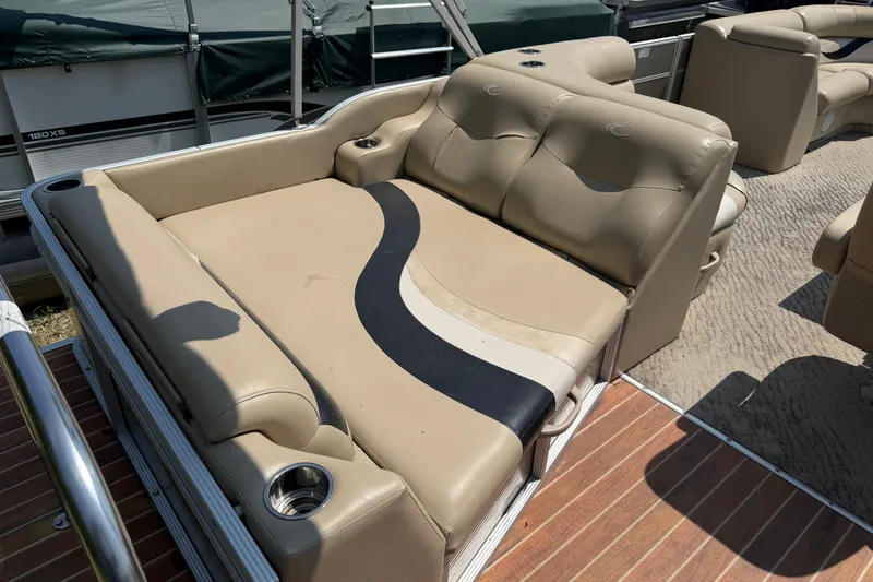 Slide: The Image of Luxurious seating on a 2012 Crest 230SLR Classic boat, featuring beige upholstery and cup holders. - 12
