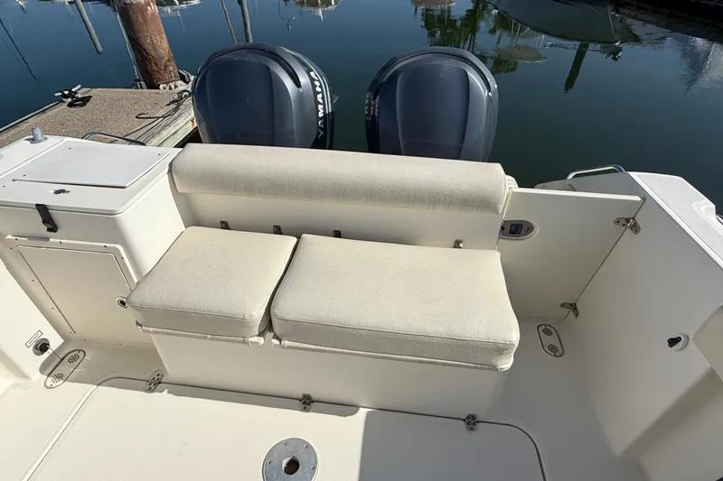 Slide: The Image of 2005 Pursuit 265 Denali LS boat interior with cushioned seating and dual Yamaha engines. - 14