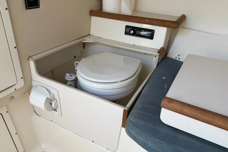 Slide: The Image of 2005 Pursuit 265 Denali LS boat interior with compact marine toilet. - 16