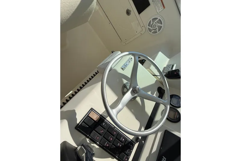 Slide: The Image of Steering wheel and controls of a 2005 Pursuit 265 Denali LS boat cockpit. - 6
