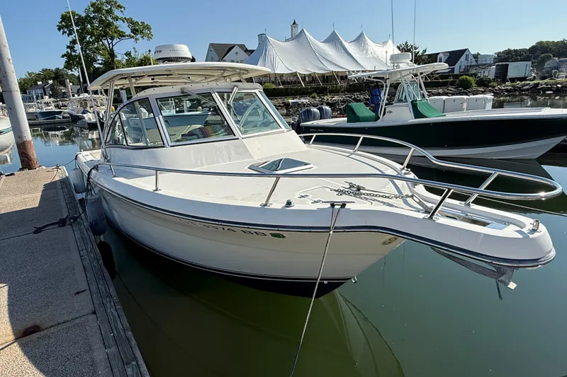Slide: The Image of 2005 Pursuit 265 Denali LS boat docked in a marina. - 2