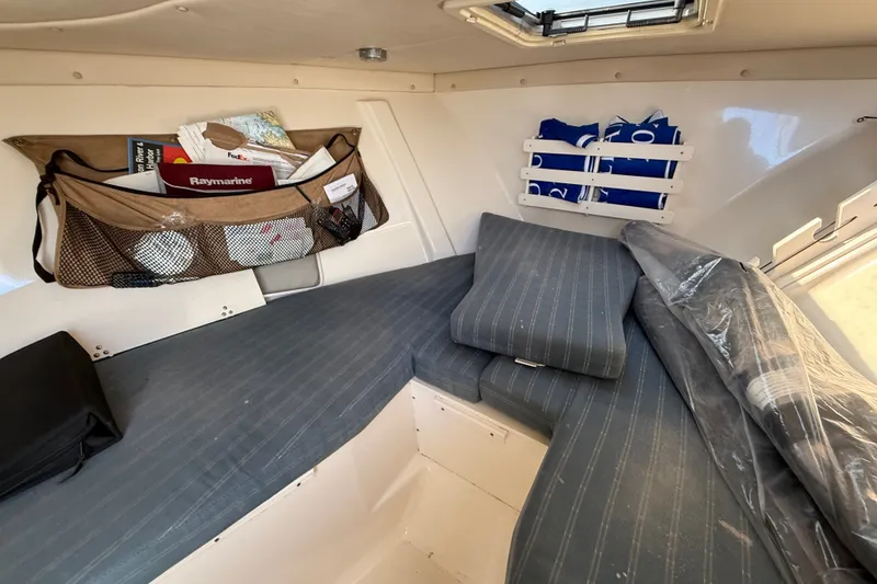 Slide: The Image of Interior cabin of a 2005 Pursuit 265 Denali LS boat with cushions and storage. - 11