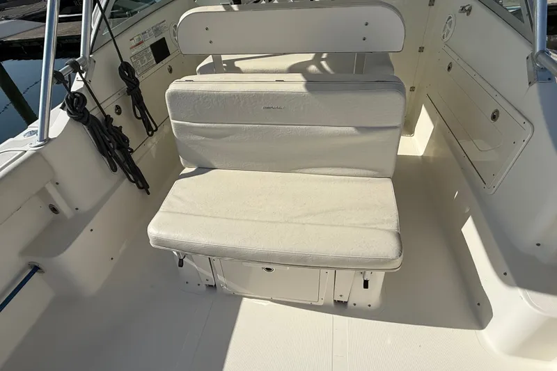 Slide: The Image of 2005 Pursuit 265 Denali LS boat interior with cushioned seating and storage. - 7