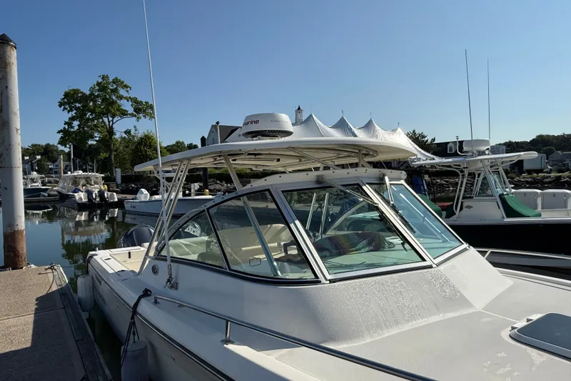 Slide: The Image of 2005 Pursuit 265 Denali LS boat docked at marina under clear blue sky. - 3