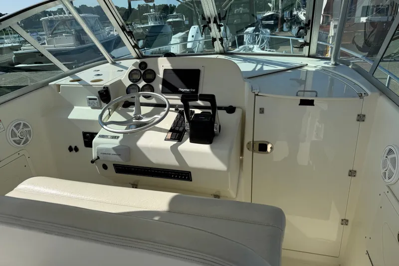 Slide: The Image of Interior helm of 2005 Pursuit 265 Denali LS boat with steering wheel and controls. - 8