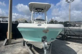 Slide: The Image of 2023 Crownline 220 CC Finseeker boat in a marina setting under a blue sky. - 3