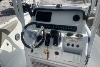 Slide: The Image of 2023 Crownline 220 CC Finseeker boat dashboard with steering wheel and controls. - 9
