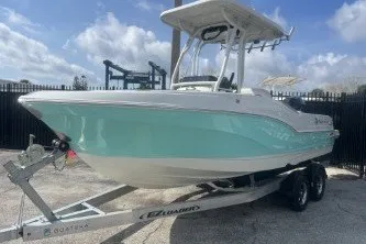 Slide: The Image of 2023 Crownline 220 CC Finseeker boat on trailer, light blue hull, parked outdoors. - 4