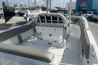 Slide: The Image of 2023 Crownline 220 CC Finseeker boat interior with seating and console, docked outdoors. - 7