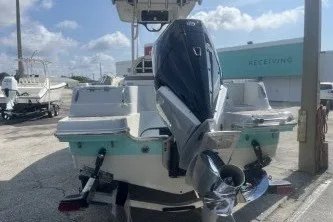Slide: The Image of 2023 Crownline 220 CC Finseeker boat with outboard motor, docked under a cloudy sky. - 6