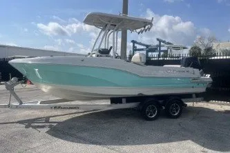 Slide: The Image of 2023 Crownline 220 CC Finseeker boat on trailer, parked outdoors under blue sky. - 5