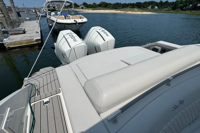 Slide: The Image of 2025 Sea Ray SLX 310 Outboard with twin engines docked by the water. - 18