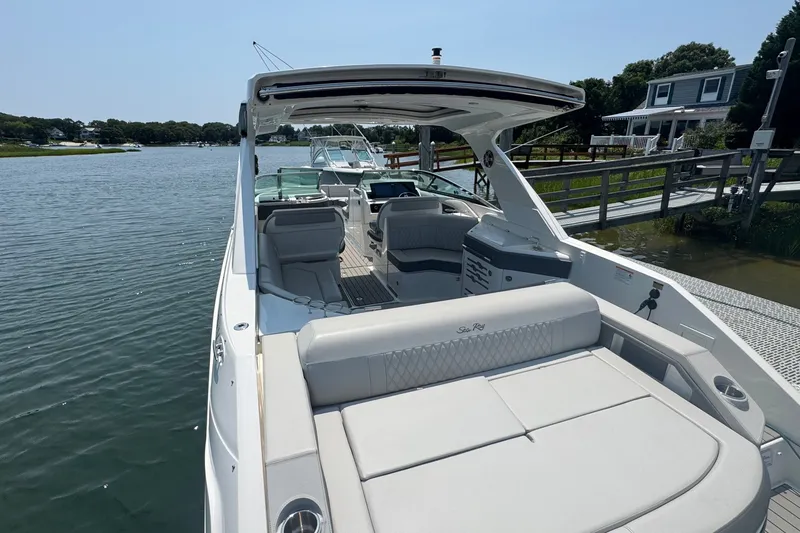 Slide: The Image of 2025 Sea Ray SLX 310 Outboard luxury boat docked by a serene waterfront. - 16