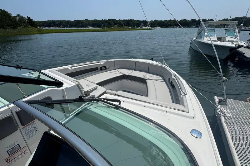 Slide: The Image of 2025 Sea Ray SLX 310 Outboard boat docked on a serene lake. - 44