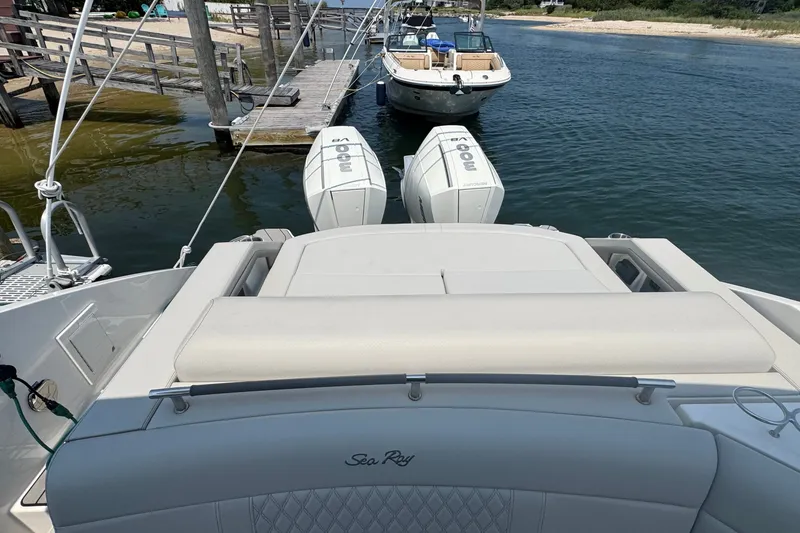 Slide: The Image of 2025 Sea Ray SLX 310 Outboard with dual engines docked by the water. - 14