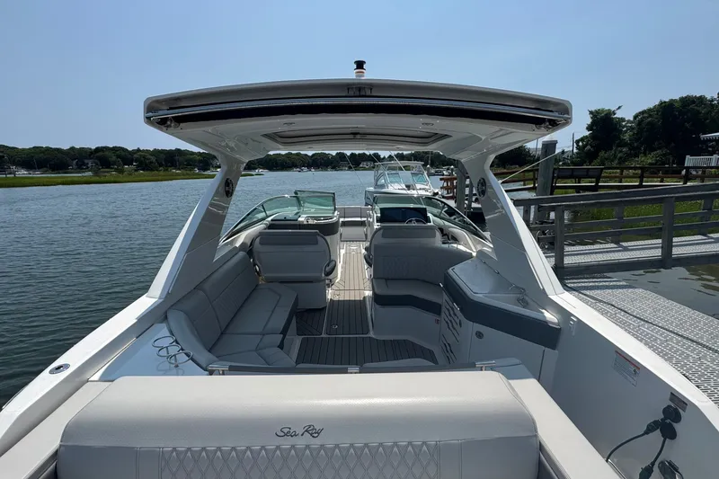 Slide: The Image of 2025 Sea Ray SLX 310 Outboard luxury boat docked by a scenic waterfront. - 15