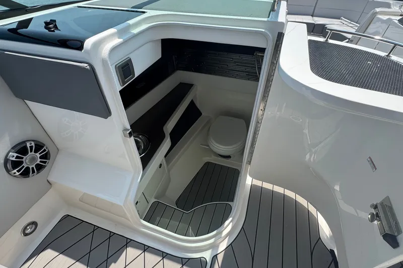 Slide: The Image of 2025 Sea Ray SLX 310 Outboard boat interior with compact bathroom and modern amenities. - 30
