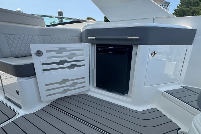Slide: The Image of 2025 Sea Ray SLX 310 Outboard interior with open storage compartment and sleek seating. - 29