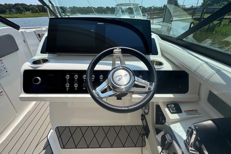 Slide: The Image of 2025 Sea Ray SLX 310 Outboard helm with modern controls and sleek steering wheel. - 37