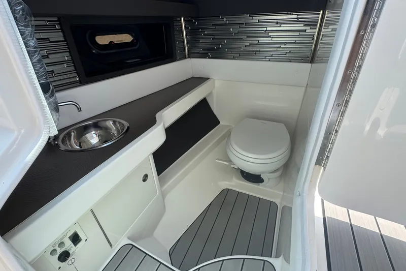 Slide: The Image of Interior of 2025 Sea Ray SLX 310 Outboard boat bathroom with sink and toilet. - 31