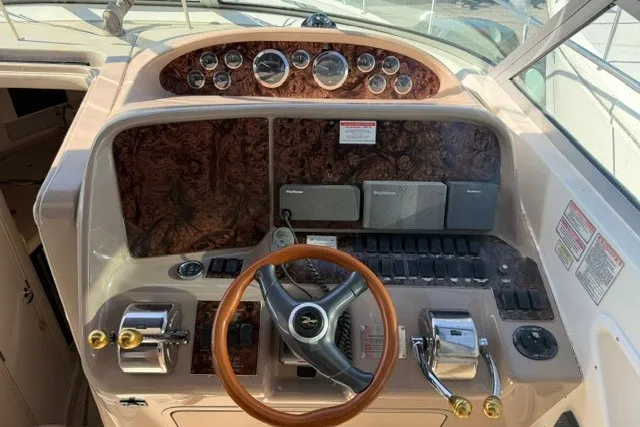 Slide: The Image of Cockpit of 1999 Sea Ray 330 Express Cruiser with wood accents and steering wheel. - 3