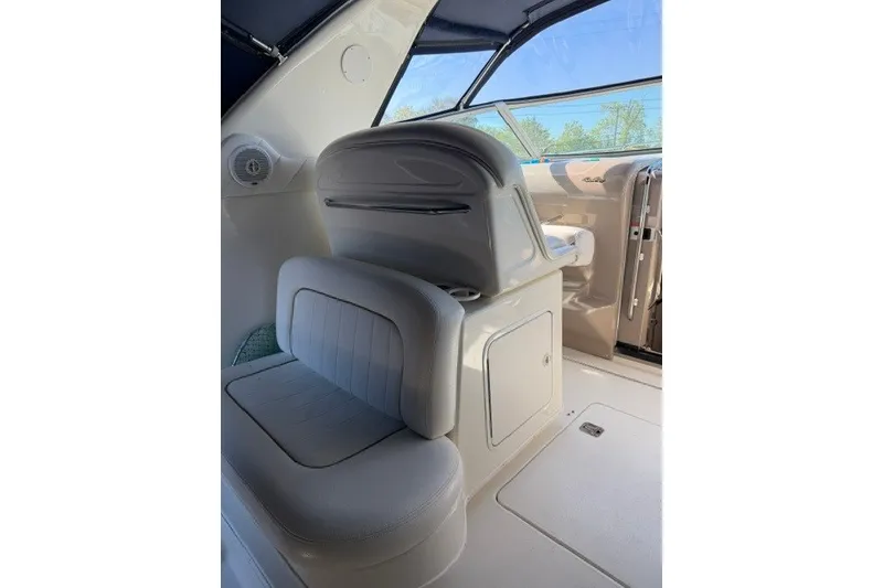 Slide: The Image of 1999 Sea Ray 330 Express Cruiser interior with white seating and helm station. - 5