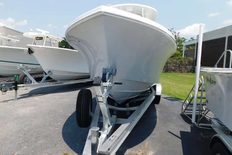Slide: The Image of 2026 Pair Customs 24 Center Console DV Offshore boat on trailer, parked outdoors. - 25